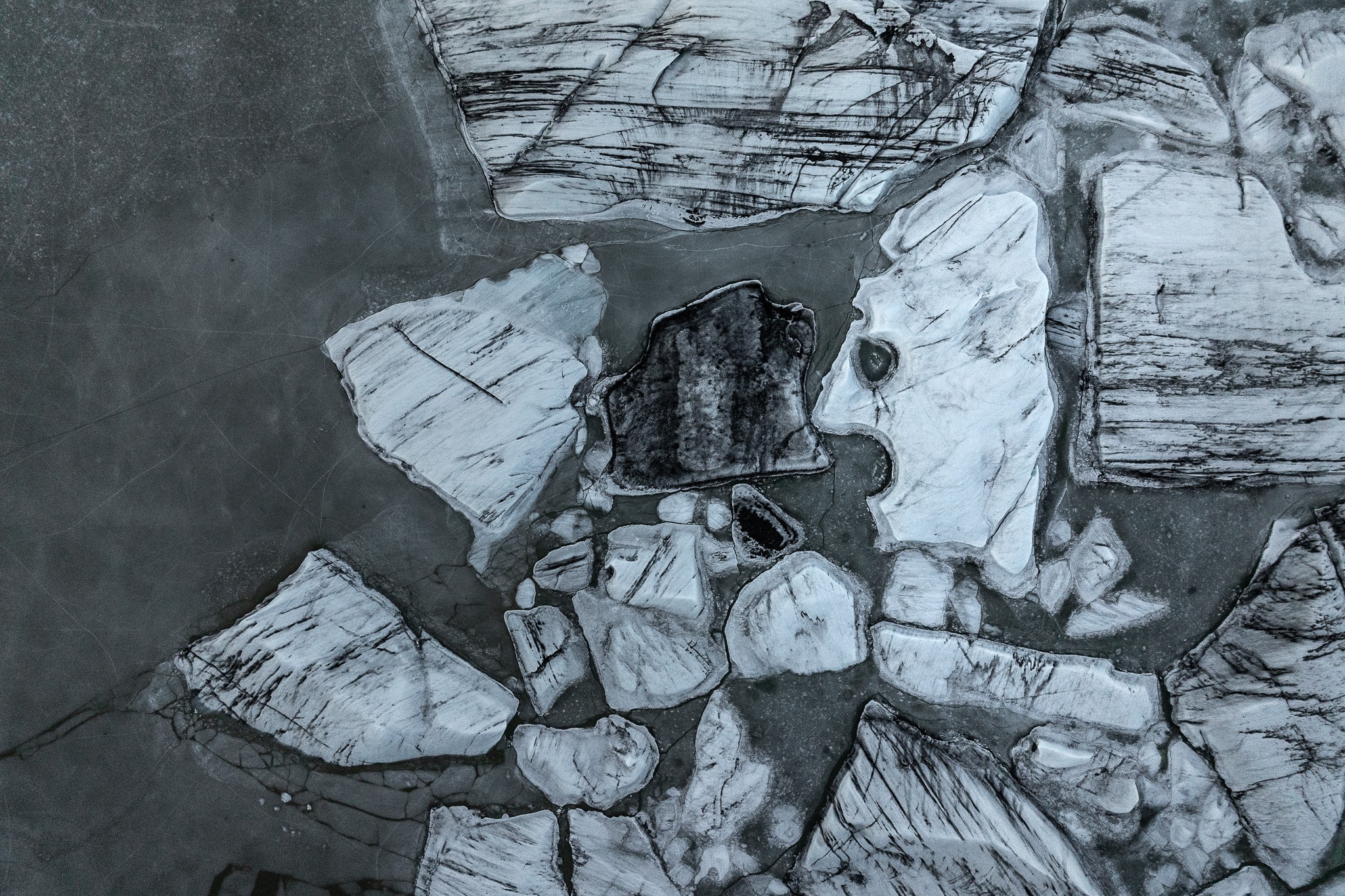Trapped in Ice: an aerial view of fractured ice and a face-shaped rock in Iceland, photographed by Alex Pansier.